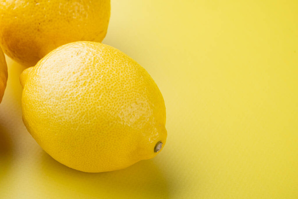 Yellow ripe lemon set, on yellow textured summer background, with copy space for text - Фото, изображение