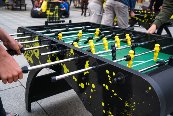 Cropped image of young people playing foosball while resting outdoors - Photo, Image
