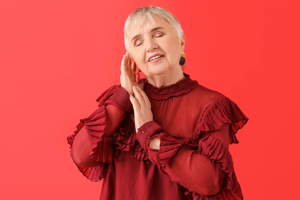 Porträt einer stilvollen Seniorin auf farbigem Hintergrund - Foto, Bild
