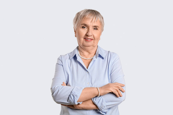 Porträt einer stilvollen Seniorin auf hellem Hintergrund - Foto, Bild