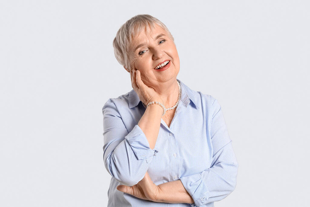 Portrait of stylish senior woman on light background - Photo, Image