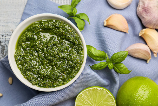Bowl with fresh pesto sauce and ingredients on table - Photo, Image