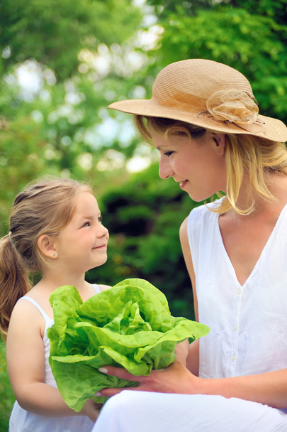 Young mother and daughter with lettuce - Photo, Image