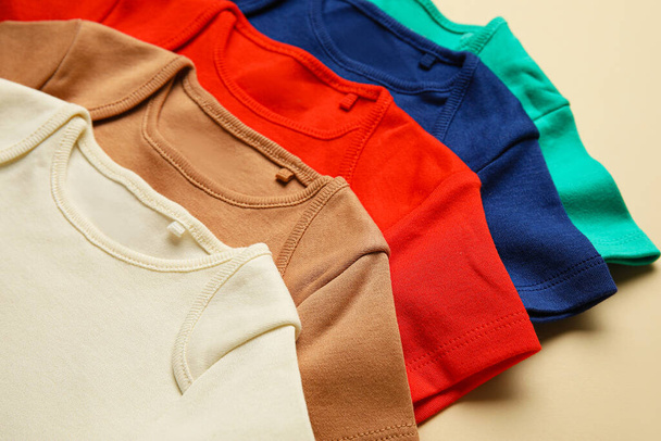 Βρεφικά ρούχα στο φόντο χρώμα, closeup - Φωτογραφία, εικόνα