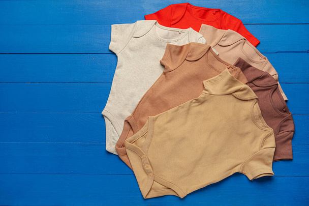 Baby clothes on color wooden background - Fotografie, Obrázek