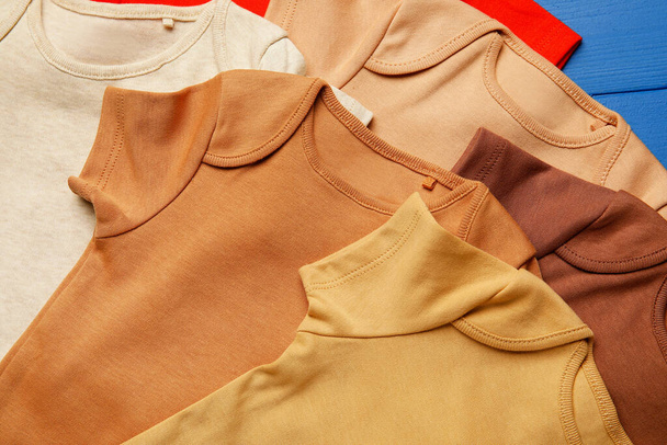 Βρεφικά ρούχα στο φόντο χρώμα, closeup - Φωτογραφία, εικόνα