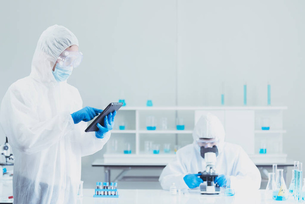 Δύο επιστήμονες της Ασίας ομάδα reserch χημείας πείραμα σωλήνα βιοτεχνολογίας δείγμα αντισωμάτων στο εργαστήριο Καλλιέργεια Εμβόλιο κατά του ιού covid-19. Επιστήμονας συμβουλεύονται, αναλύουν στο Εργαστήριο Χημείας - Φωτογραφία, εικόνα