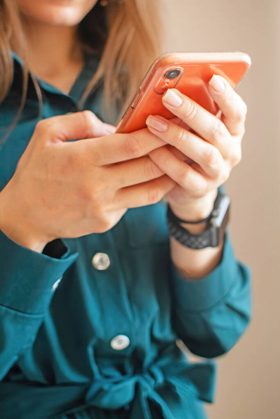 Mujer joven usando smartphone para videollamadas, para realizar un pedido en la tienda online. Las manos femeninas sostienen un teléfono inteligente. - Foto, Imagen