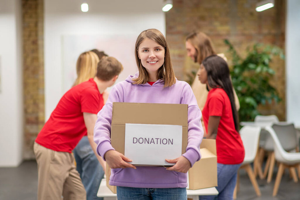 Young girl holding box with charity aid - Фото, зображення