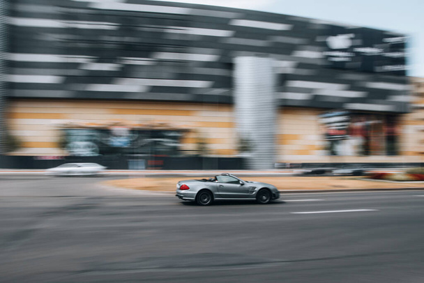 Украина, Киев - 27 июня 2021 года: Серебряный автомобиль Mercedes-Benz SL-класса AMG движется по улице. Осторожно! - Фото, изображение