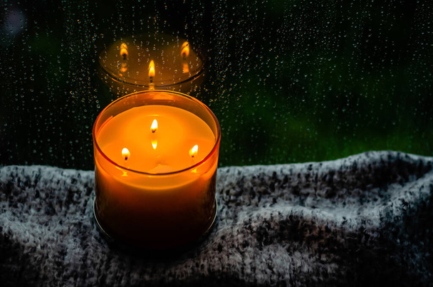 Καίγοντας κερί άρωμα βάζει στο τραπέζι με ύφασμα κοντά από το παράθυρο που έχουν πτώση βροχής την εποχή των μουσώνων. Zen και να χαλαρώσετε έννοια. - Φωτογραφία, εικόνα