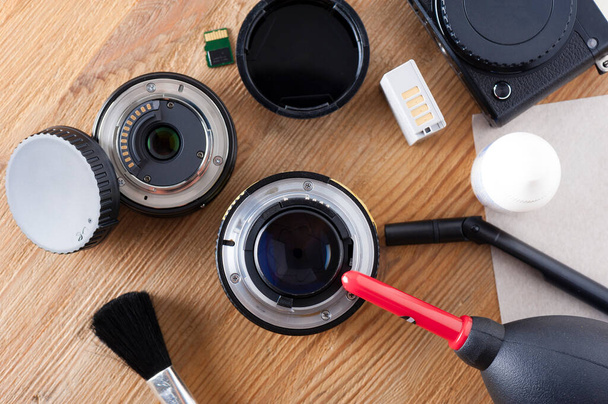Kamera und Objektiv passen auf. Kamera-Reinigungs-Sets und Kameraausrüstung auf dem Desktop des Fotografen. - Foto, Bild
