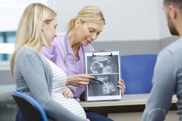 young pregnant woman visiting experienced doctor gynecologist - Foto, Bild