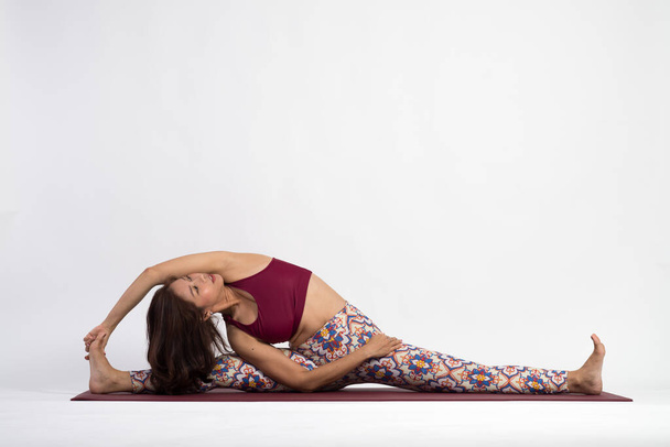 young asian woman practicing yoga with white wall on background - Photo, Image