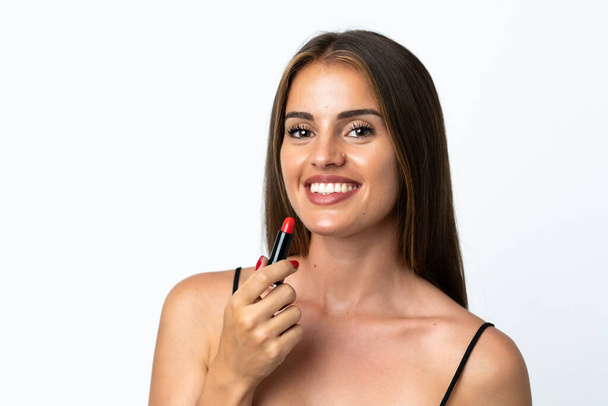 Jeune femme uruguayenne isolée sur fond blanc tenant rouge à lèvres - Photo, image