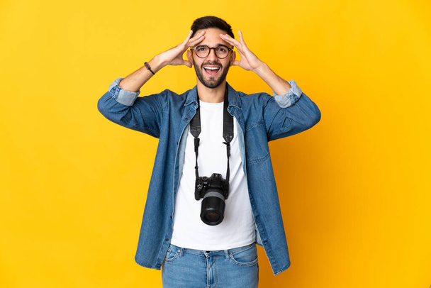 Junges Fotografenmädchen isoliert auf gelbem Hintergrund mit überraschendem Ausdruck - Foto, Bild