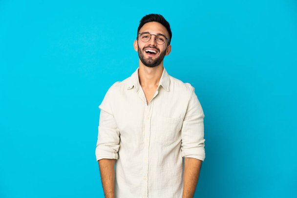 Young caucasian man isolated on blue background with surprise facial expression - Φωτογραφία, εικόνα