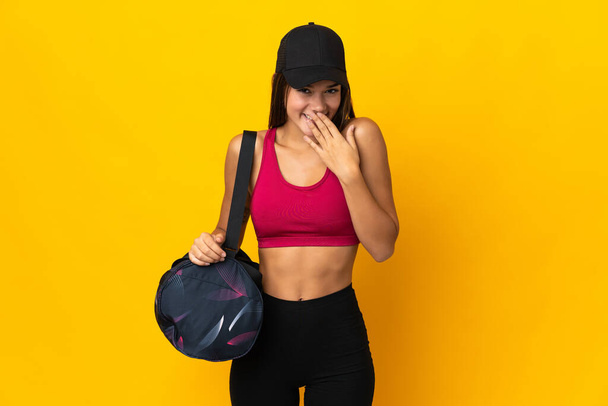 Teenager sport girl with sport bag happy and smiling covering mouth with hand - Photo, image