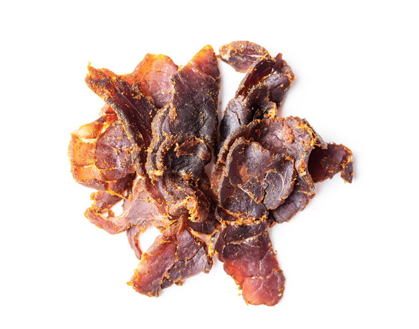 Sliced beef jerky. Dried beef meat isolated on white background. - Zdjęcie, obraz