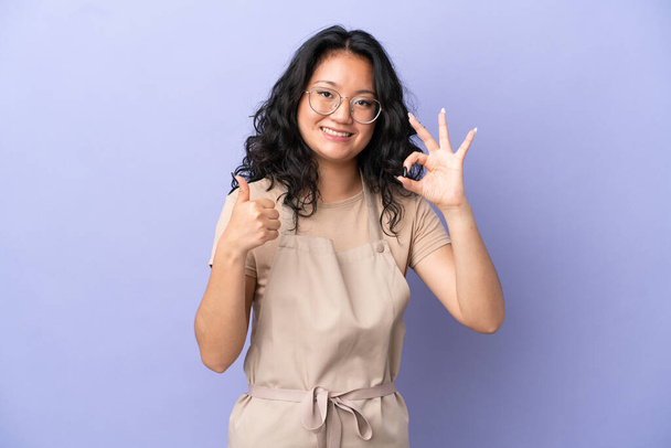 Restaurant asian waiter isolated on purple background showing ok sign and thumb up gesture - Foto, Imagem