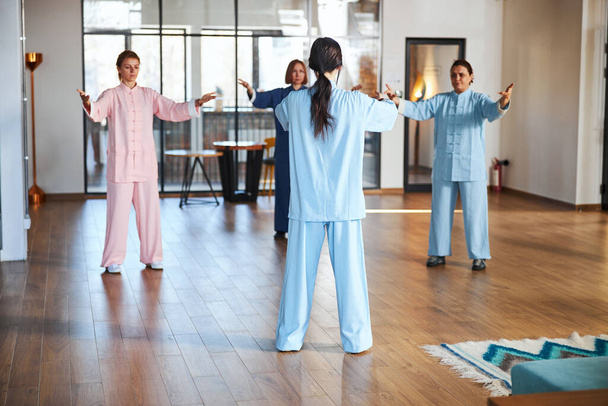 Grupa osób ćwiczących qigong ze swoim mistrzem - Zdjęcie, obraz