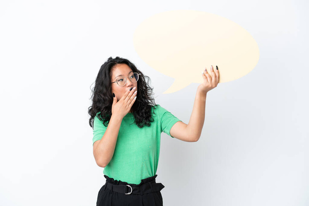 Young asian woman isolated on white background holding an empty speech bubble with surprised expression - Photo, Image