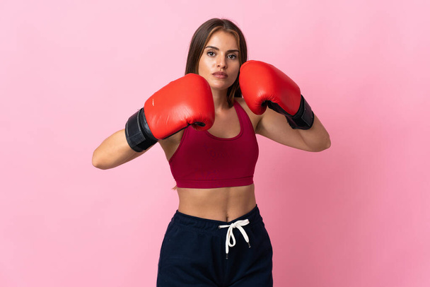 Young Uruguayan woman isolated on pink background with boxing gloves - Foto, afbeelding