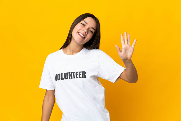 tiener vrijwilliger meisje tellen vijf met vingers - Foto, afbeelding