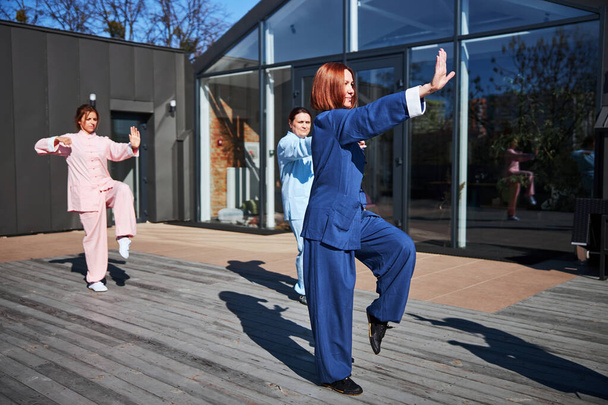 Körperliche Übungen der Kampfkunst auf sonniger Terrasse - Foto, Bild