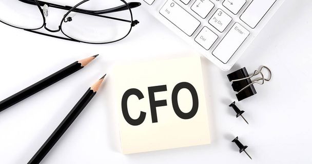 Текст CFO на наклейці з клавіатурою, олівцями та офісними інструментами
 - Фото, зображення