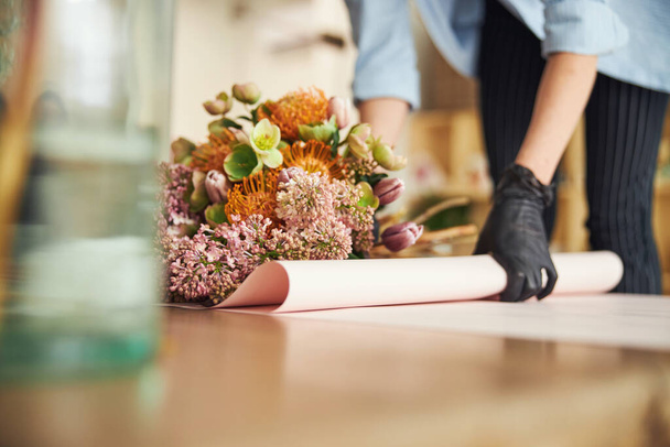 Nainen nitriilikäsineissä työstämässä kevään kukka-asetelmaa - Valokuva, kuva