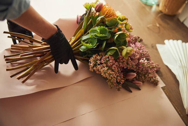 Hyväksytty kukkakauppias kääriminen kimppu pöydälle - Valokuva, kuva
