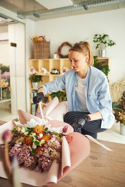 Smiling lady finishing off a floral arrangement - Photo, Image