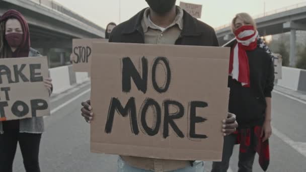 Portrait dressé de jeunes masques debout sur l'autoroute et portant des pancartes en signe de protestation - Séquence, vidéo