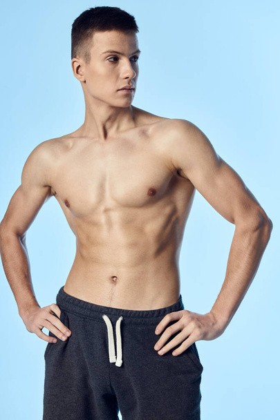 athletic guy with a naked inflated torso holds his hands on his belt look to the side - Foto, immagini