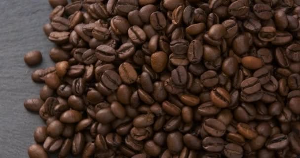 ダークコーヒーの穀物。焙煎したコーヒー豆が回転する。香り高いアラビカとロブスタ。ビデオを回転させる。ループ動作.  - 映像、動画