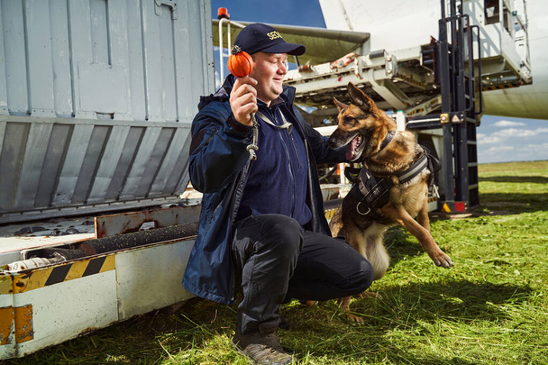 Oficial de segurança treinando cão de detecção no aeródromo - Foto, Imagem