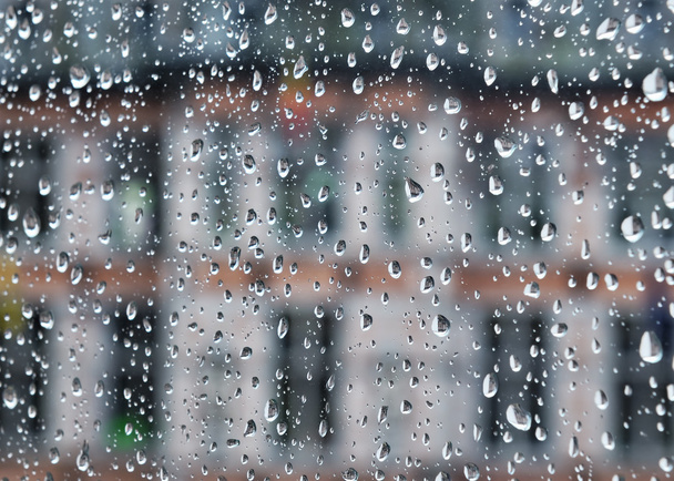 Edificio visible a través de vidrio cubierto por gotas de lluvia
 - Foto, Imagen