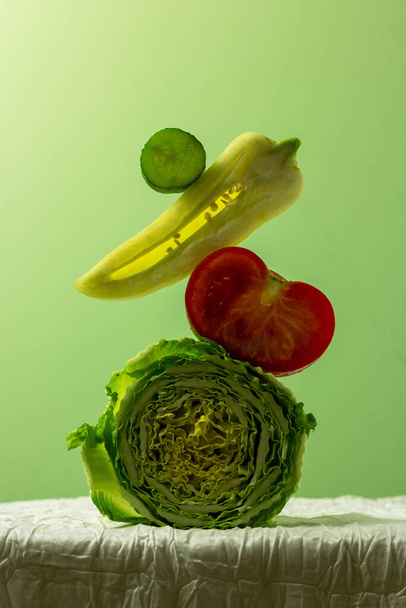 Kapusta, pomidor, pieprz, ogórek, na zielonym tle. Równowaga bilansu żywnościowego. Kopiuj kartę papieru kosmicznego. - Zdjęcie, obraz