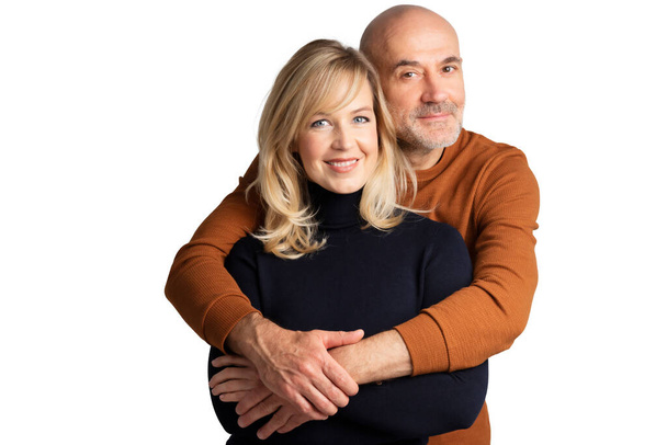Studio shot of happy couple standing together at isolated white background. Man hugging his partner.  - Φωτογραφία, εικόνα