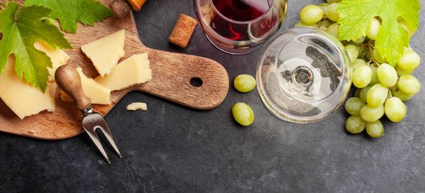 Copas de vino blanco y tinto, tabla de uva y aperitivo con queso. Vista superior plano laico - Foto, Imagen
