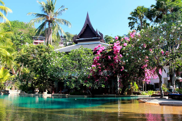 Gyönyörű a legnagyobb szabad formájú lagúna medence körül pálmafák és virágos fák Thavorn Beach Village Resort & Spa, napos nap, Phuket, Thaiföld - Fotó, kép