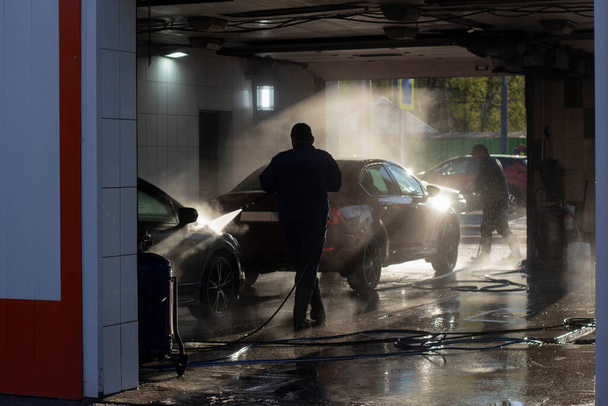 Car wash at a car wash. Workers wash their cars under the pressure of water. Wash your car yourself. - Φωτογραφία, εικόνα