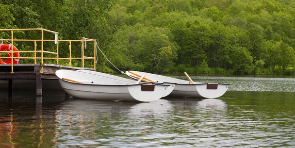 boats with oars near the pier on the lake - Photo, Image