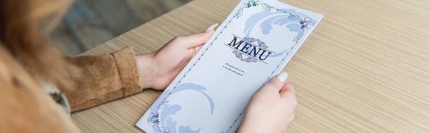 Vista cortada de mulher segurando menu no café, banner  - Foto, Imagem