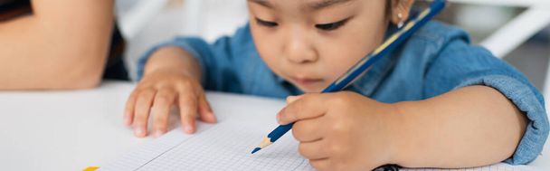 Blurred asian girl drawing on notebook, banner  - Фото, изображение