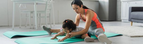 Asian mother stretching with daughter on fitness mat, banner  - Photo, Image