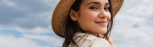 pleased young woman in sun hat against blue sky, banner - Photo, Image