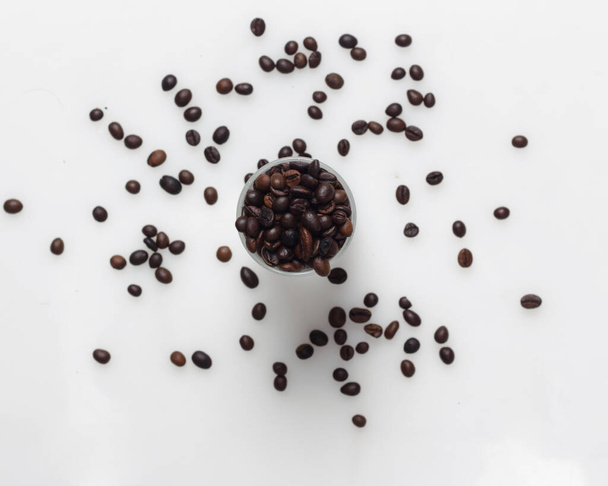 Κόκκοι καφέ σε ένα φωτεινό λευκό φόντο. Αυτός είναι ένας κόκκος καφέ αραβικά. Η χαρακτηριστική γεύση του καφέ Arabica έχει τη μορφή ελαφράς σύστασης και υψηλότερου επιπέδου οξύτητας από τους άλλους καφέδες.. - Φωτογραφία, εικόνα
