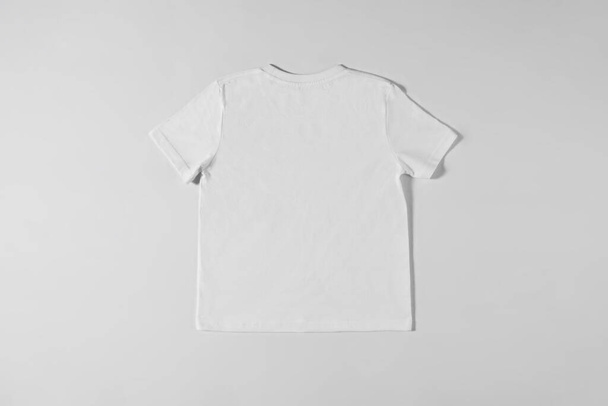 White T-shirt lying on a light background - Foto, Imagen
